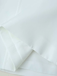Close-up detail of smooth white fabric texture and neat stitching on top hemline