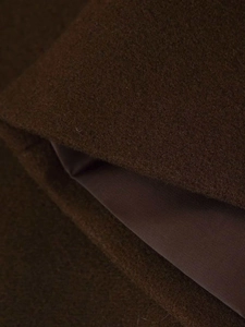 Macro shot of dark brown wool coat fabric texture and smooth inner lining finish