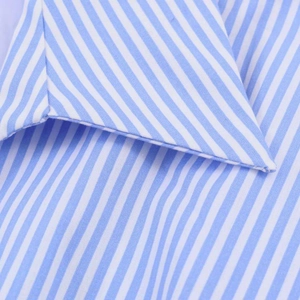 Detail shot of the pointed collar and blue white striped poplin fabric of the shirt