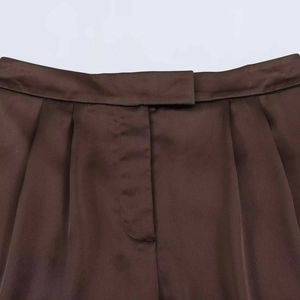 Deep brown high-waisted shorts featuring smooth satin fabric and elegant pleated details