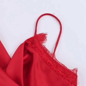 Close-up of red satin top featuring delicate eyelash lace trim and thin spaghetti straps