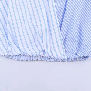 Detail of blue striped poplin shirt featuring wrap design and elasticated smocked hem