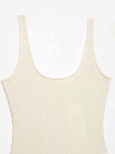 Detail of light beige knitted vest showing scalloped trim and ribbed texture