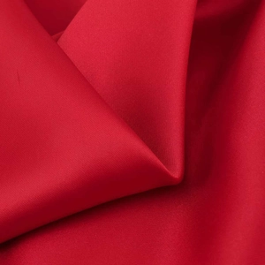 Detailed view of red silky satin fabric with natural drape and glossy pleated textures