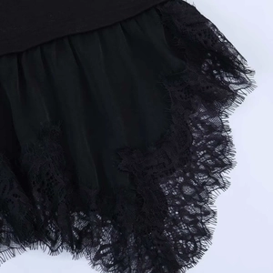 Detailed close-up of delicate black eyelash lace trim on a women irregular short sleeve top