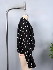 Detail of classic black polka dot jacket with buttoned cuffs on long sleeves