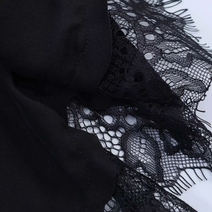 Macro shot of eyelash lace trim and premium chiffon stitching on a black t-shirt