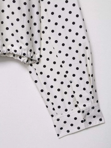 Détails du chemisier à pois avec poignets boutonnés et ourlet élastique à cordon serrage
