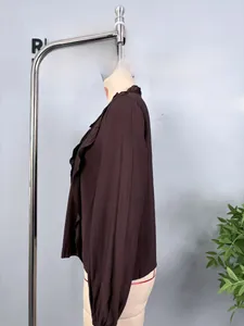 Detailed side view of brown chiffon shirt featuring elegant ruffles and tiered lace trim