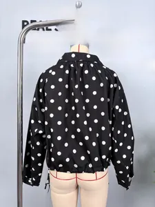 Detailed shot of black polka dot jacket sleeve showing button cuff and drawcord hem