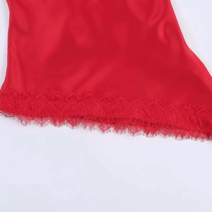 Detailed macro view of the red satin fabric hem featuring delicate eyelash lace trim
