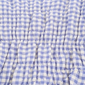Close-up of blue and white gingham fabric with elastic shirred stitching texture