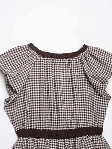 Detailed macro shot of brown checkered seersucker top with elastic collar and waist ribbons