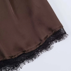 Detailed macro view of smooth brown satin fabric with intricate black eyelash lace hem