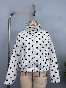 Detail of white long sleeve polka dot jacket with high collar and elastic hemline