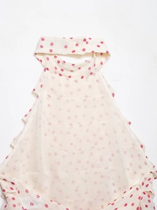 Détail du haut dos nu blanc à pois roses avec des volants délicats sur les côtés