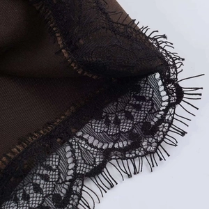 Close-up of intricate black eyelash lace detail on brown high-waist summer shorts