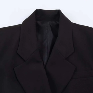 Close-up of black blazer lapel and interior lining showing premium woven fabric texture