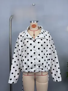 Detailed view of white polka dot jacket featuring elastic hem and button closure