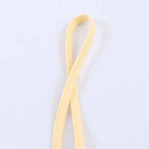 Detail of light yellow satin strap with neat stitching on a lace camisole top