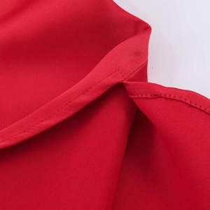 Detail view of high-quality red lace top featuring a side slit and precision stitching