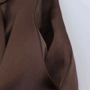 Detail of brown twill shorts showing high-quality stitching on the pocket side
