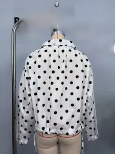 Back view detail of white polka dot shirt featuring long sleeves and drawstring hem