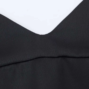 Detailed close-up of the delicate fabric texture and V-neckline stitching of the black satin top