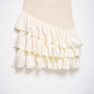 Beige tiered ruffle mini dress featuring asymmetric layers and textured fabric