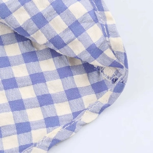 Detail shot of the blue gingham fabric texture and stitching on the midi dress hemline