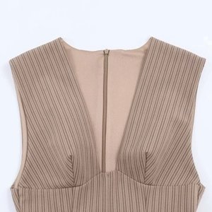 Detail of khaki sleeveless dress featuring a deep V-neckline and a discreet hidden zipper