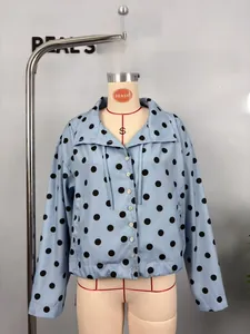 Detail view of light blue polka dot long sleeve jacket with drawstring hem and buttons