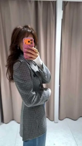 Detail view of houndstooth plaid blazer featuring double-breasted buttons and notch lapels