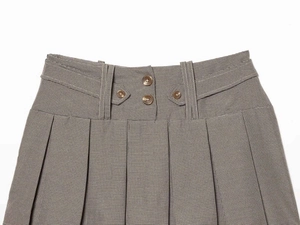 Macro view of high-waist plaid pleated skirt showing double-breasted buttons and pleats