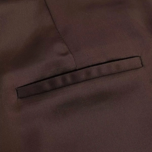 Detailed close-up of a neat welt pocket on dark brown high-waisted shorts with twill texture