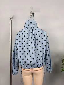 Detail of light blue polka dot jacket showing drawstring hem and pleated back design
