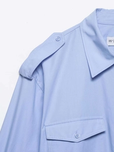 Gros plan d'une chemise bleu clair montrant les épaulettes et les coutures du col