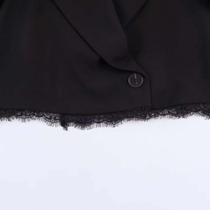 Detail of black suit jacket featuring delicate lace trim and eyelash lace hemline decor