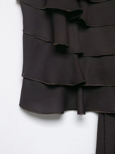 Détails de volants superposés marron foncé avec coutures raffinées sur tissu mousseline