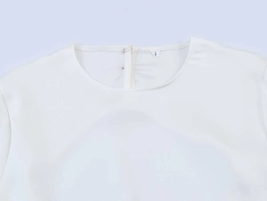 Detail of white chiffon top neckline featuring neat stitching and S size tag