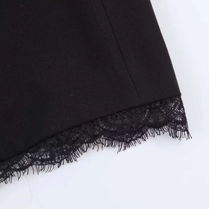 Close-up of black blazer hem featuring delicate eyelash lace trim and textured woven fabric