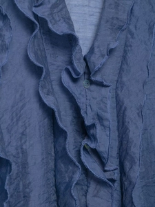 Detailed view of dark blue chiffon blouse with layered ruffles and tonal resin buttons