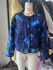 Détail d'une veste d'hiver matelassée avec imprimé tie-dye abstrait et boutons-pression