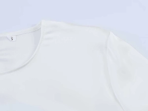 Close-up of the white chiffon top crew neck showing detailed stitching and size S label