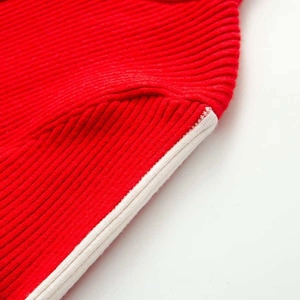 Vista macro del tessuto a maglia a coste rosso con bordino bianco per tuta da sci