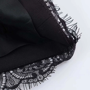 Detail of delicate black eyelash lace trim and textured fabric on summer suit jacket