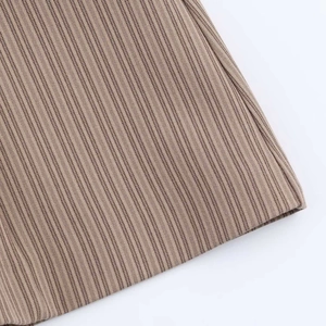 Detail shot of the brown ribbed knit fabric texture of the sleeveless V-neck mini dress