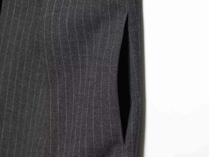 Détail du pantalon gris foncé à rayures montrant la texture fine et la poche latérale invisible