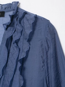 Close-up detail of dark blue chiffon blouse featuring intricate layered ruffle trimmings