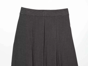 Détail du pantalon gris foncé à rayures avec taille en V et texture fine du tissu